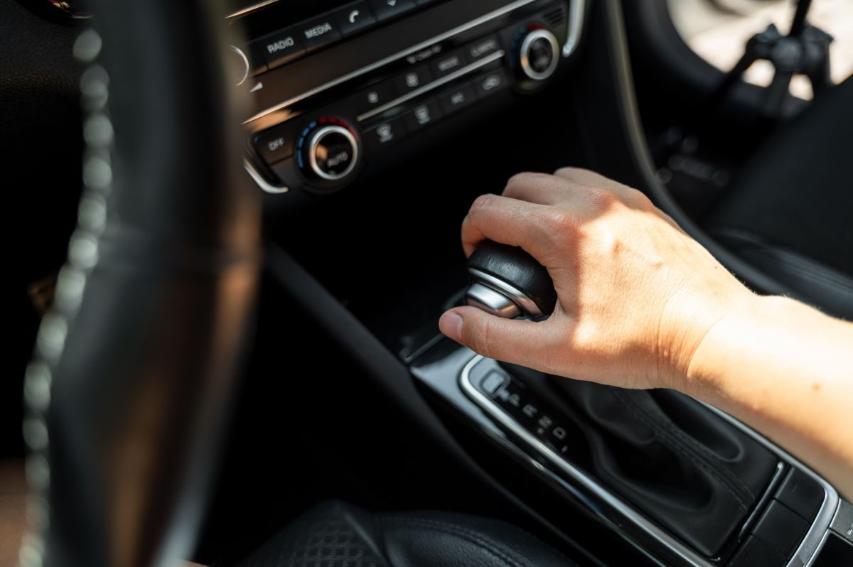 A hand on the gear shifter inside a car