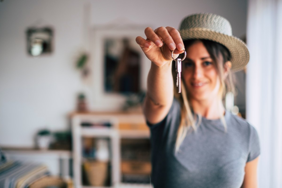 A woman holding up the keys to her home